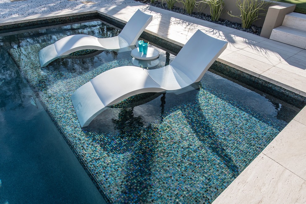 This is an example of a large contemporary backyard rectangular lap pool in Phoenix with a water feature and tile.