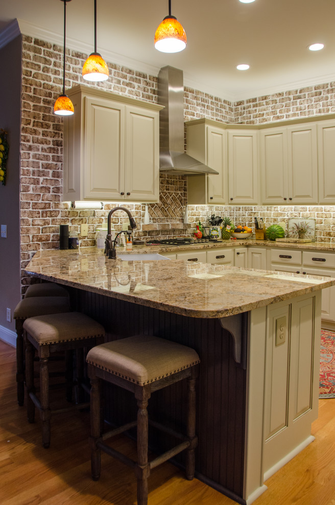 Large transitional u-shaped medium tone wood floor eat-in kitchen photo in Raleigh with a farmhouse sink, raised-panel cabinets, beige cabinets, granite countertops, multicolored backsplash, terra-cotta backsplash, stainless steel appliances and a peninsula