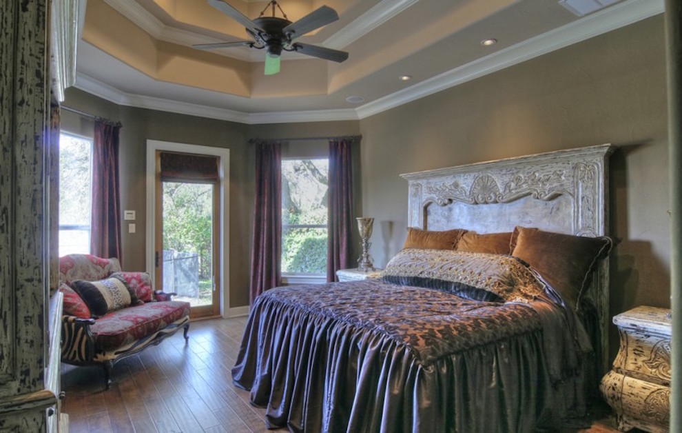 Photo of a large mediterranean master bedroom in Austin with beige walls and medium hardwood floors.