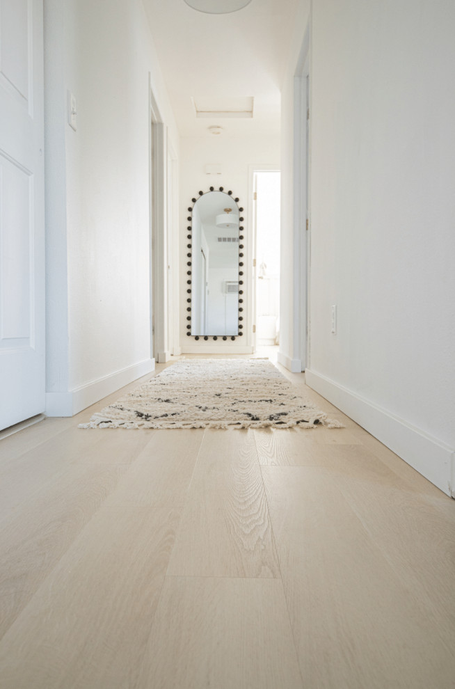 Exempel på en mellanstor minimalistisk hall, med vita väggar, vinylgolv och beiget golv
