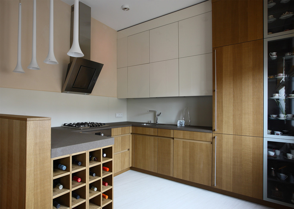 Small contemporary u-shaped open plan kitchen in Moscow with a drop-in sink, flat-panel cabinets, beige cabinets, granite benchtops, grey splashback, glass tile splashback, stainless steel appliances, no island and grey benchtop.