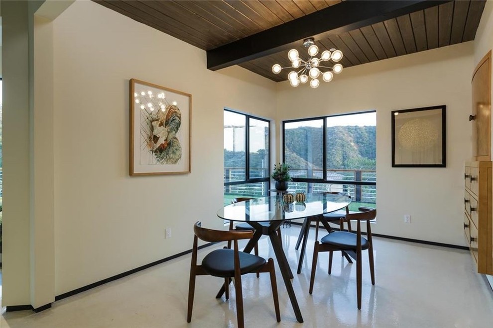 This is an example of a small modern separate dining room in Los Angeles with white walls and no fireplace.