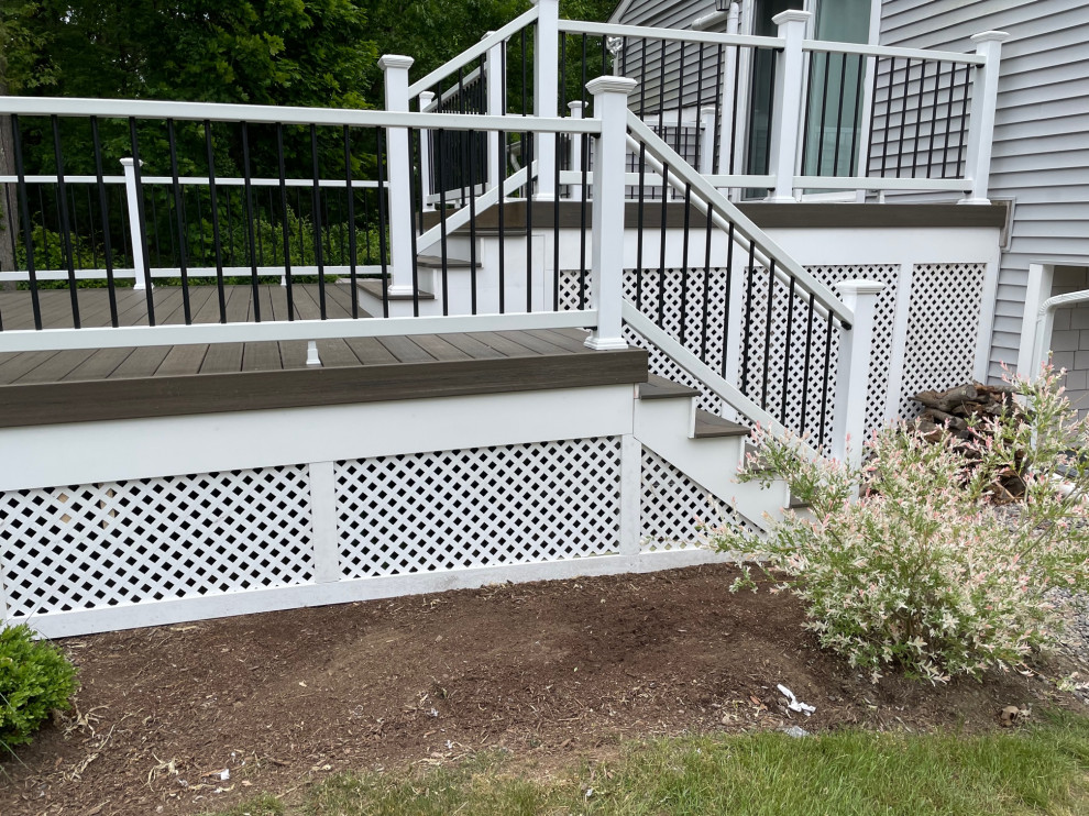 Photo of a large transitional side yard and first floor deck in Providence with mixed railing.