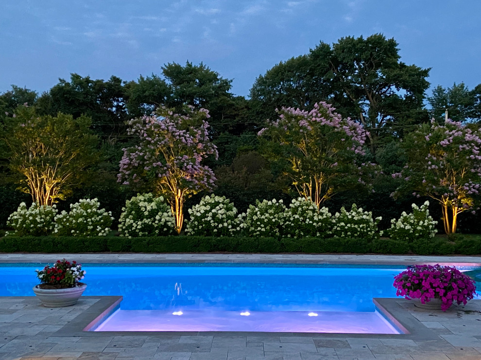 Imagen de piscina alargada clásica extra grande a medida en patio trasero con paisajismo de piscina y adoquines de piedra natural