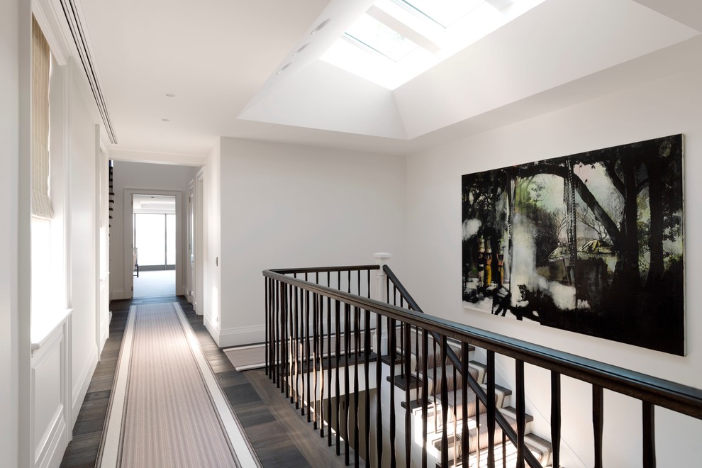 This is an example of a transitional hallway in Sydney with white walls and dark hardwood floors.
