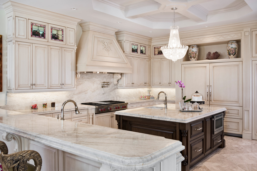 Design ideas for a mediterranean u-shaped kitchen in Miami with an undermount sink, beaded inset cabinets, beige cabinets, beige splashback, panelled appliances, with island and beige floor.