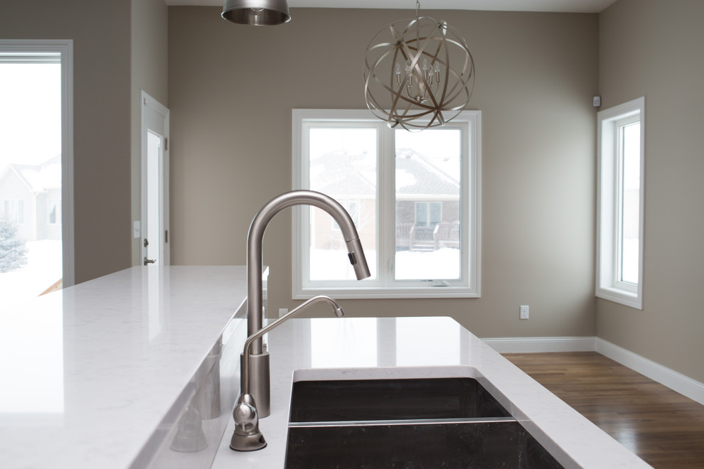 Enclosed kitchen - mid-sized transitional l-shaped dark wood floor enclosed kitchen idea with a double-bowl sink, shaker cabinets, dark wood cabinets, quartz countertops, gray backsplash, stone tile backsplash, stainless steel appliances and an island