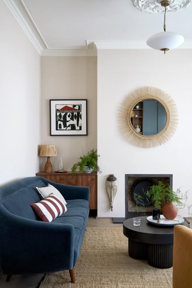 Immagine di un soggiorno minimalista di medie dimensioni e chiuso con pareti beige, parquet chiaro, nessun camino e TV nascosta