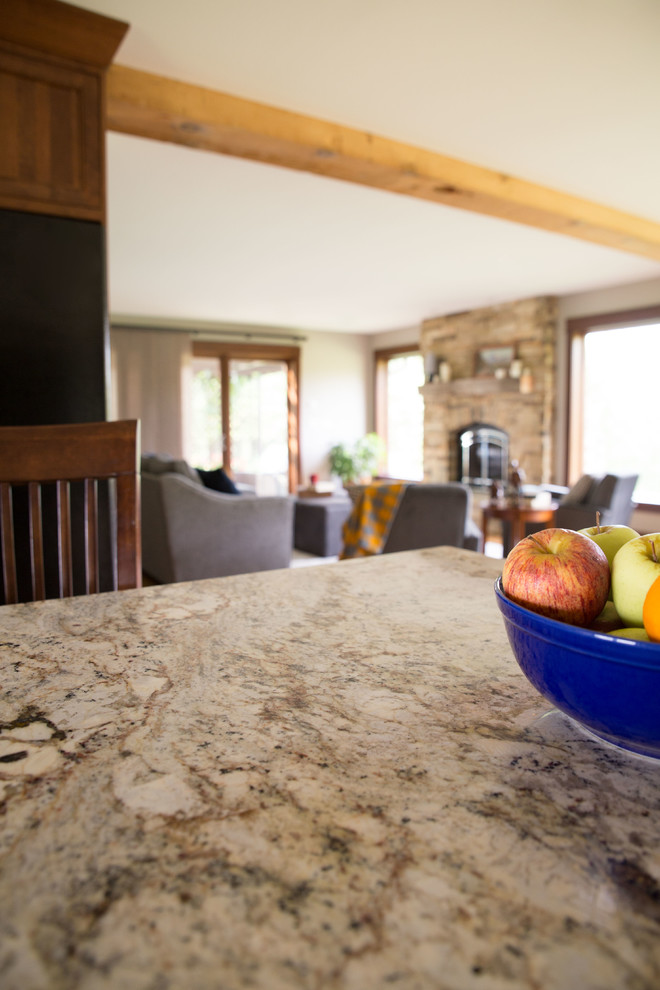 Open concept kitchen - mid-sized rustic galley light wood floor open concept kitchen idea in Cedar Rapids with recessed-panel cabinets, medium tone wood cabinets, granite countertops, black appliances, an island, an undermount sink and multicolored countertops