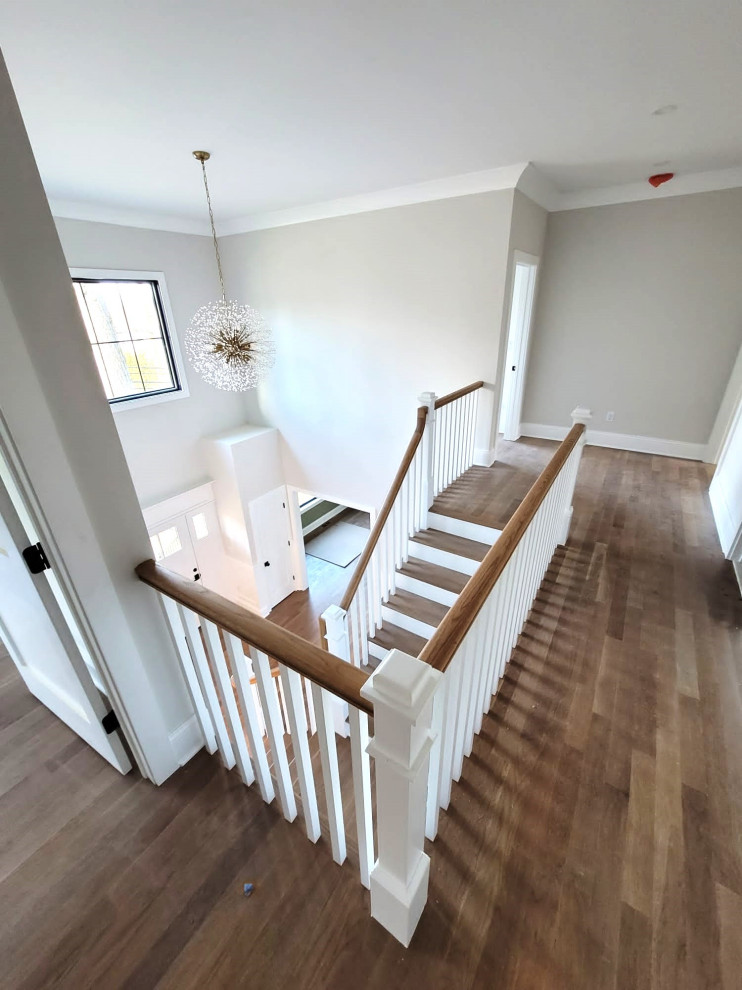This is an example of a mid-sized traditional wood l-shaped staircase in New York with wood risers and wood railing.