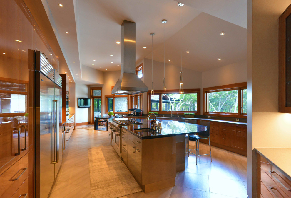 Design ideas for a large contemporary open plan kitchen in Austin with a submerged sink, flat-panel cabinets, medium wood cabinets, granite worktops, beige splashback, glass sheet splashback, stainless steel appliances, porcelain flooring, an island, grey floors and black worktops.