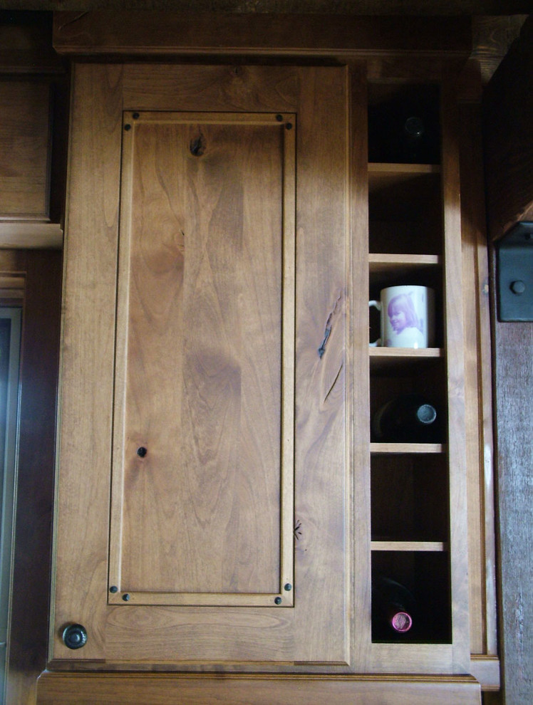 Inspiration for a mid-sized rustic u-shaped light wood floor kitchen pantry remodel in Denver with a farmhouse sink, flat-panel cabinets, dark wood cabinets, granite countertops, black backsplash, stone slab backsplash, stainless steel appliances and no island