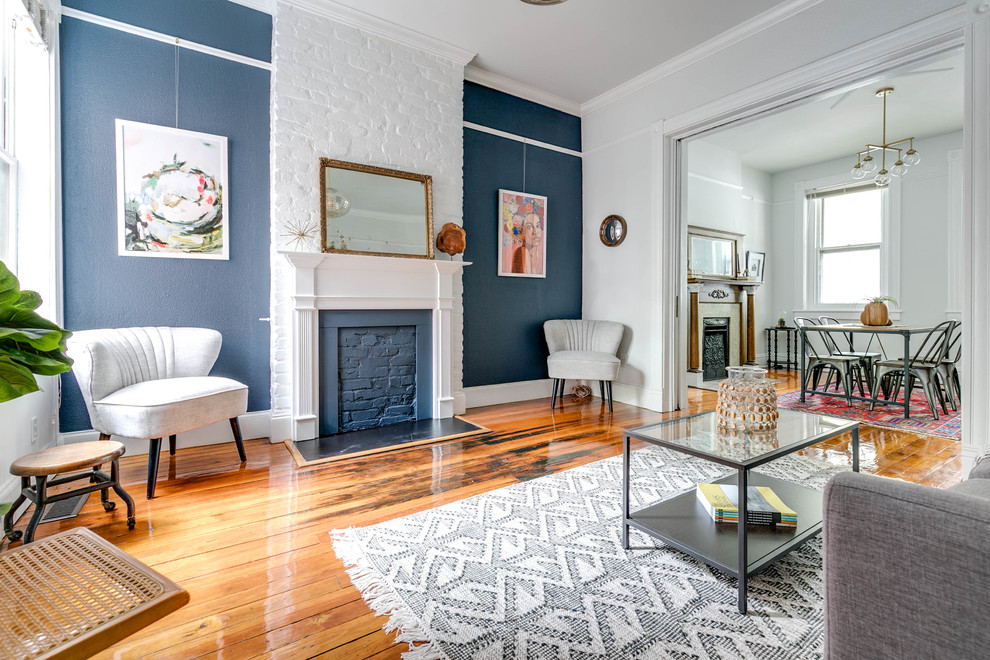 Inspiration for a mid-sized traditional formal open concept living room in Wilmington with blue walls, medium hardwood floors, a standard fireplace, a wood fireplace surround, no tv and brown floor.
