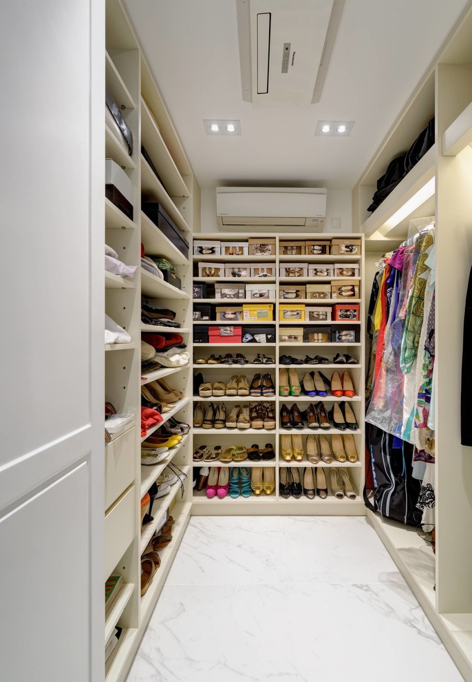 This is an example of a mid-sized contemporary walk-in wardrobe in Hong Kong with open cabinets, white cabinets and marble floors.