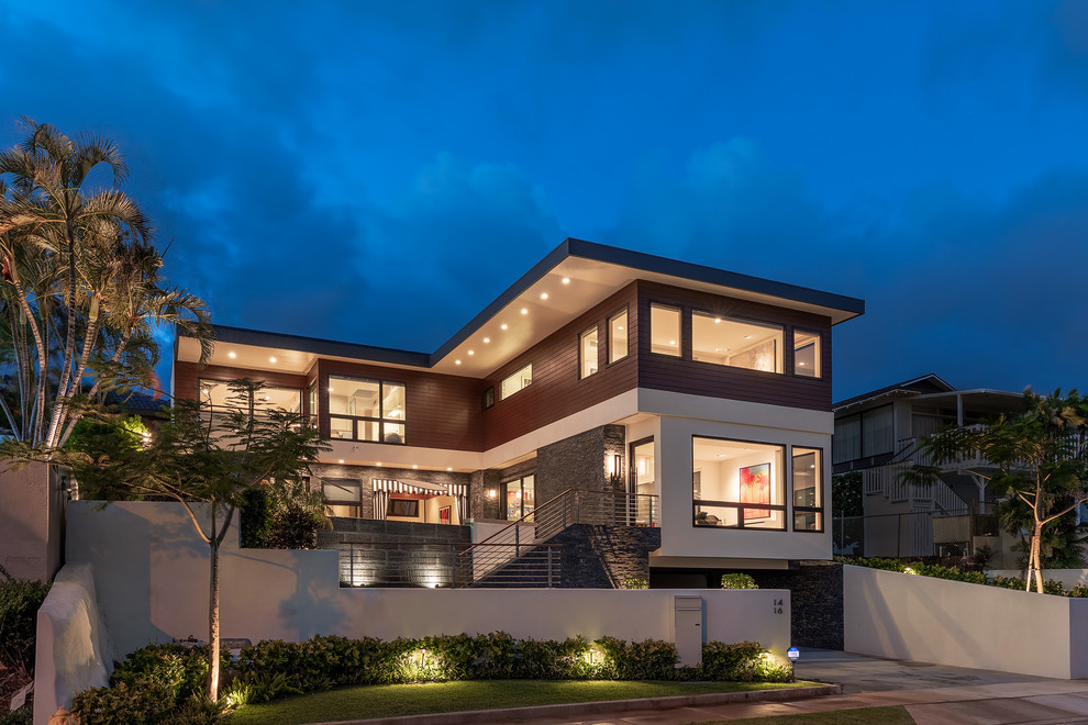 This is an example of a large modern two-storey brown house exterior in Hawaii with mixed siding and a flat roof.