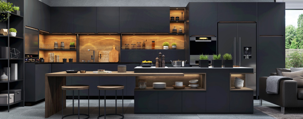 Photo of a mid-sized midcentury l-shaped open plan kitchen in Phoenix with an undermount sink, flat-panel cabinets, black cabinets, wood benchtops, brown splashback, timber splashback, black appliances, ceramic floors, with island, grey floor and black benchtop.
