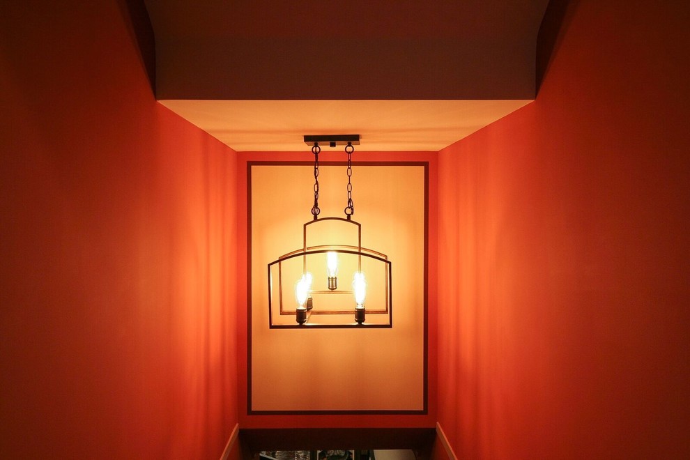 Basement - mid-sized transitional underground medium tone wood floor and brown floor basement idea in Vancouver with orange walls, a standard fireplace and a stone fireplace