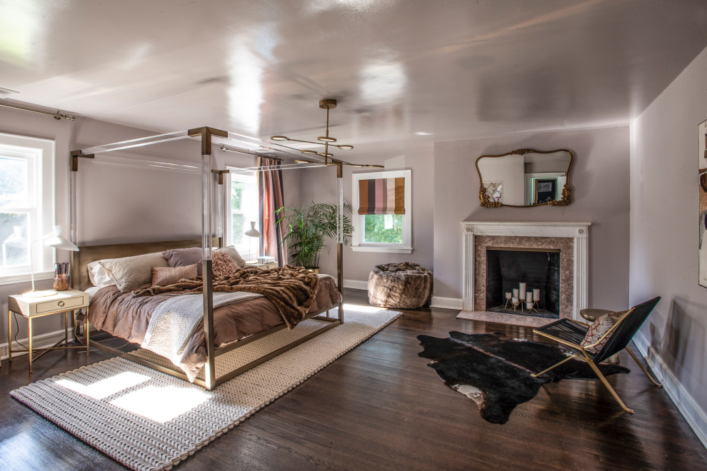 Contemporary bedroom in New York with grey walls, dark hardwood floors, a standard fireplace and brown floor.