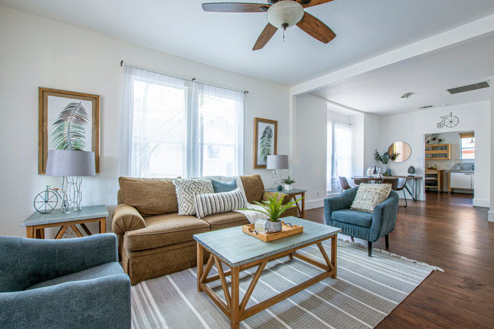 This is an example of a transitional living room in Austin with white walls, dark hardwood floors and brown floor.