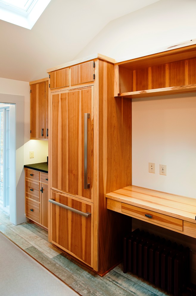 Inspiration for a large rustic u-shaped enclosed kitchen remodel with a farmhouse sink, flat-panel cabinets, medium tone wood cabinets, soapstone countertops, stainless steel appliances and an island