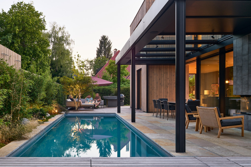 Photo of a modern swimming pool in Munich with a bbq area.