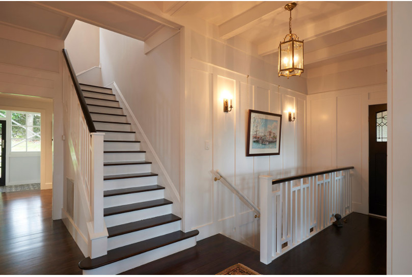 Mid-sized transitional wooden u-shaped wood railing and wainscoting staircase photo in Kansas City with painted risers
