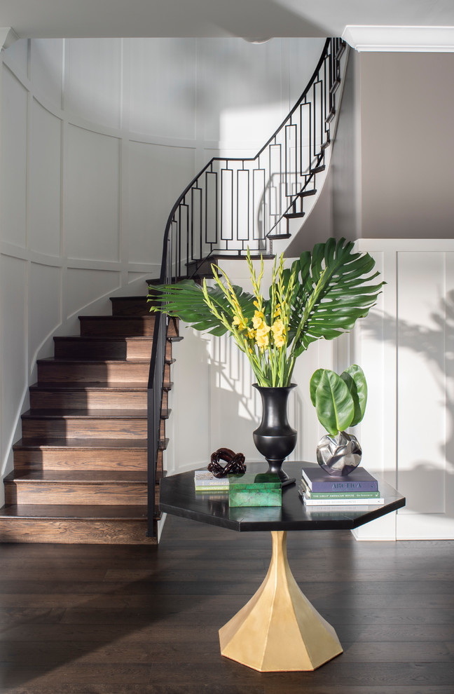 Inspiration for a large transitional wood curved staircase in Los Angeles with wood risers and metal railing.