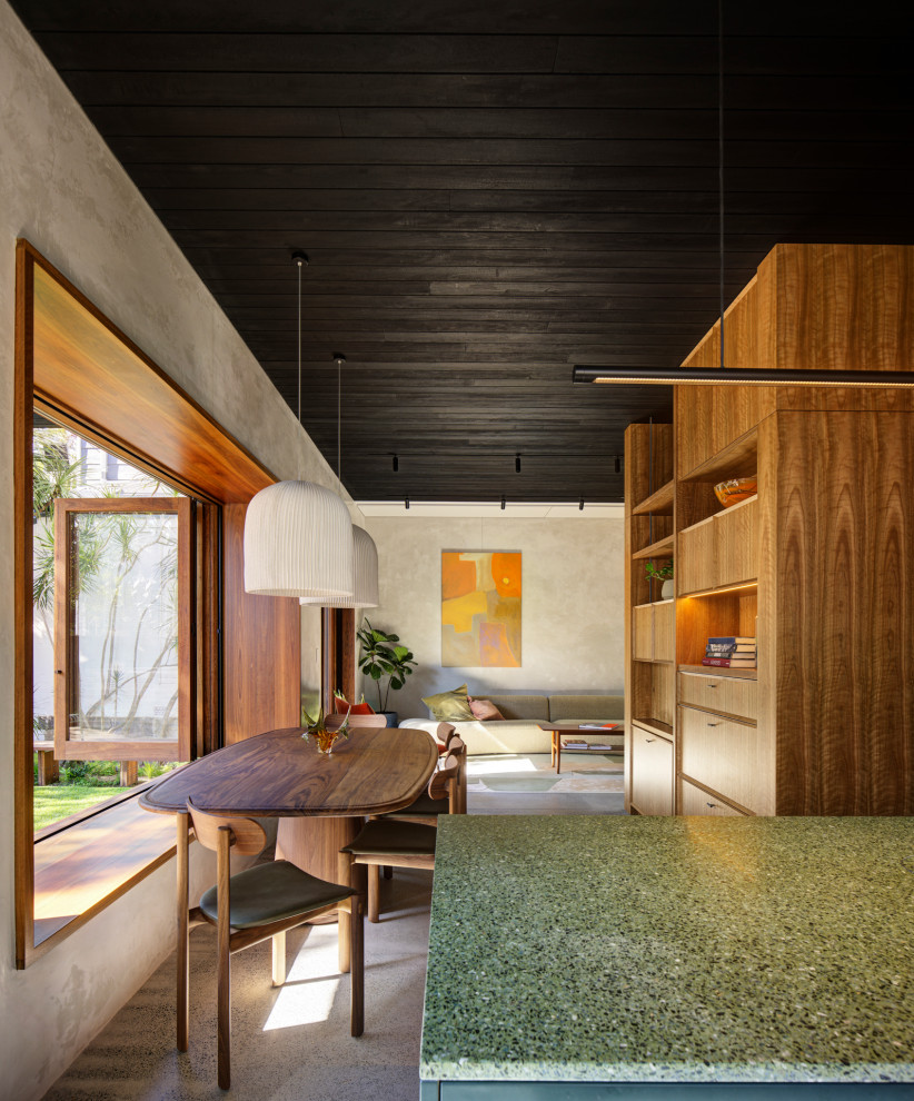 Midcentury open plan dining in Sydney with grey walls, concrete floors, grey floor and wood.