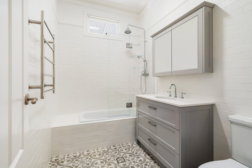 Idéer för ett mellanstort klassiskt vit en-suite badrum, med vita skåp, en hörndusch, en toalettstol med hel cisternkåpa, vit kakel, keramikplattor, mosaikgolv, ett avlångt handfat, bänkskiva i kvarts, beiget golv och dusch med gångjärnsdörr
