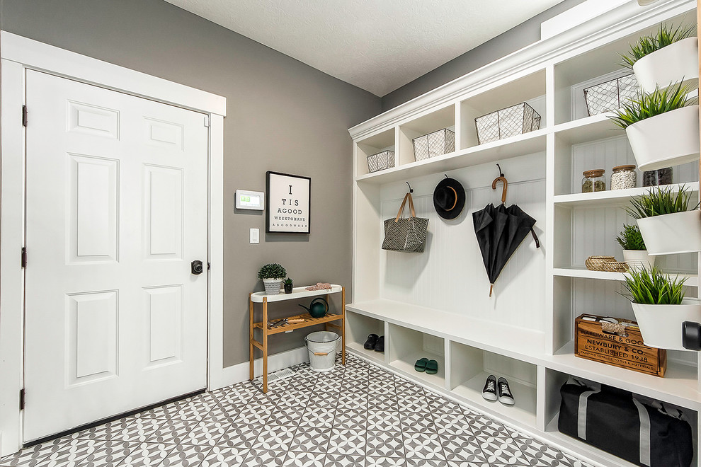 This is an example of a mid-sized midcentury mudroom in Columbus with multi-coloured walls, ceramic floors, a single front door, a yellow front door and multi-coloured floor.