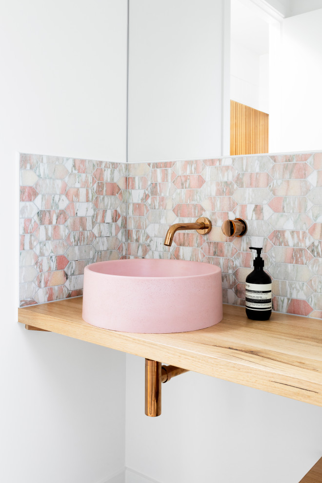 Inspiration for a large contemporary 3/4 bathroom in Melbourne with open cabinets, medium wood cabinets, pink tile, ceramic tile, white walls, a trough sink, wood benchtops, beige benchtops, a single vanity and a floating vanity.