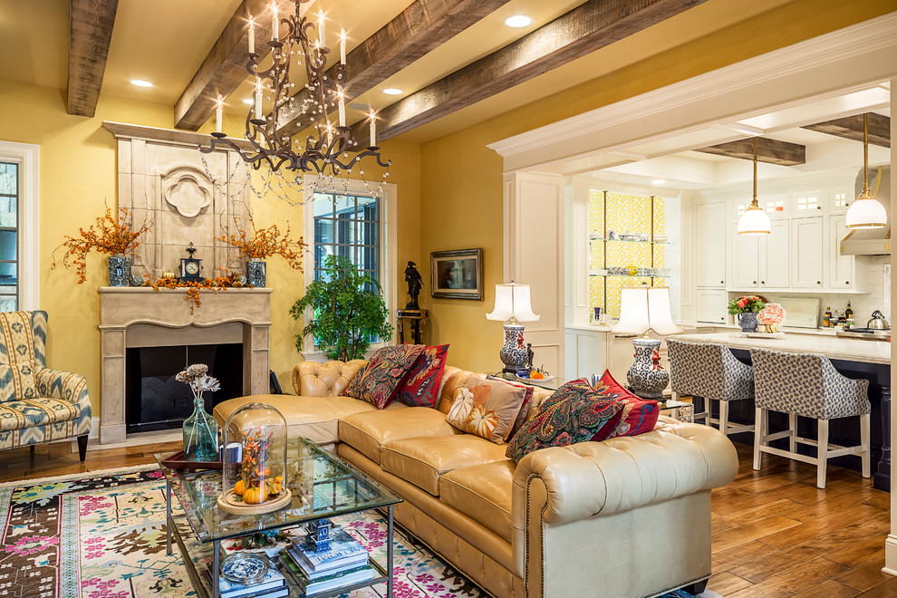 Design ideas for a mid-sized eclectic open concept family room in Chicago with yellow walls, medium hardwood floors, a standard fireplace, a stone fireplace surround and a built-in media wall.