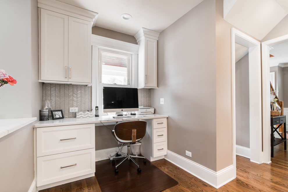Mid-sized transitional l-shaped medium tone wood floor and brown floor eat-in kitchen photo in Chicago with an undermount sink, recessed-panel cabinets, white cabinets, quartzite countertops, gray backsplash, subway tile backsplash, black appliances, no island and multicolored countertops