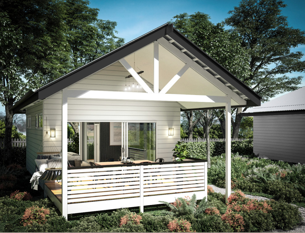 Inspiration for a small beach style one-storey white house exterior with wood siding, a gable roof and a metal roof.