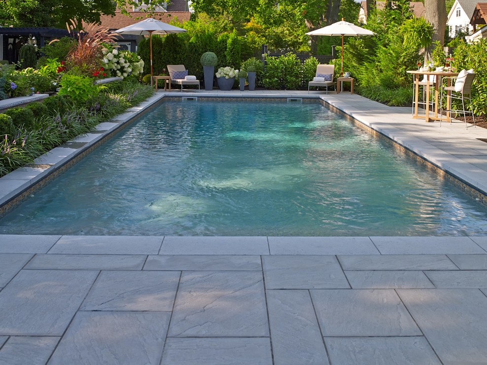Design ideas for a mid-sized transitional backyard rectangular lap pool in New York with with a pool and concrete slab.