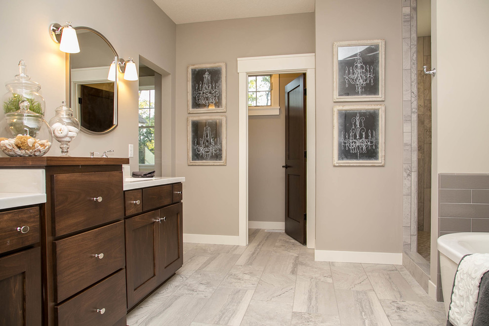 Inspiration for a transitional master gray tile and ceramic tile ceramic tile freestanding bathtub remodel in Minneapolis with an undermount sink, recessed-panel cabinets, medium tone wood cabinets, marble countertops, a one-piece toilet and gray walls