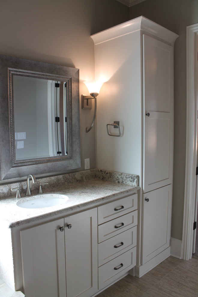 This is an example of a mid-sized contemporary master bathroom in Dallas with an undermount sink, shaker cabinets, white cabinets, granite benchtops, a drop-in tub, a corner shower, a two-piece toilet, beige tile, ceramic tile, grey walls and ceramic floors.