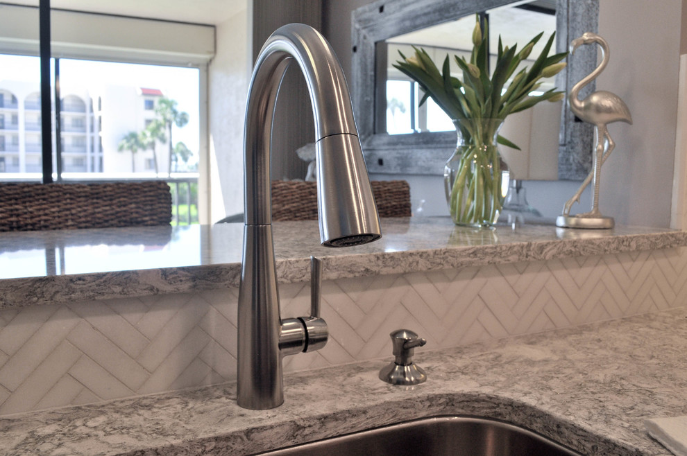 Mid-sized transitional u-shaped eat-in kitchen photo with an undermount sink, shaker cabinets, white cabinets, quartz countertops, white backsplash, marble backsplash, stainless steel appliances and no island