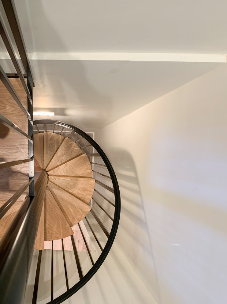 Inspiration for a large contemporary wood spiral staircase in DC Metro with wood risers and mixed railing.
