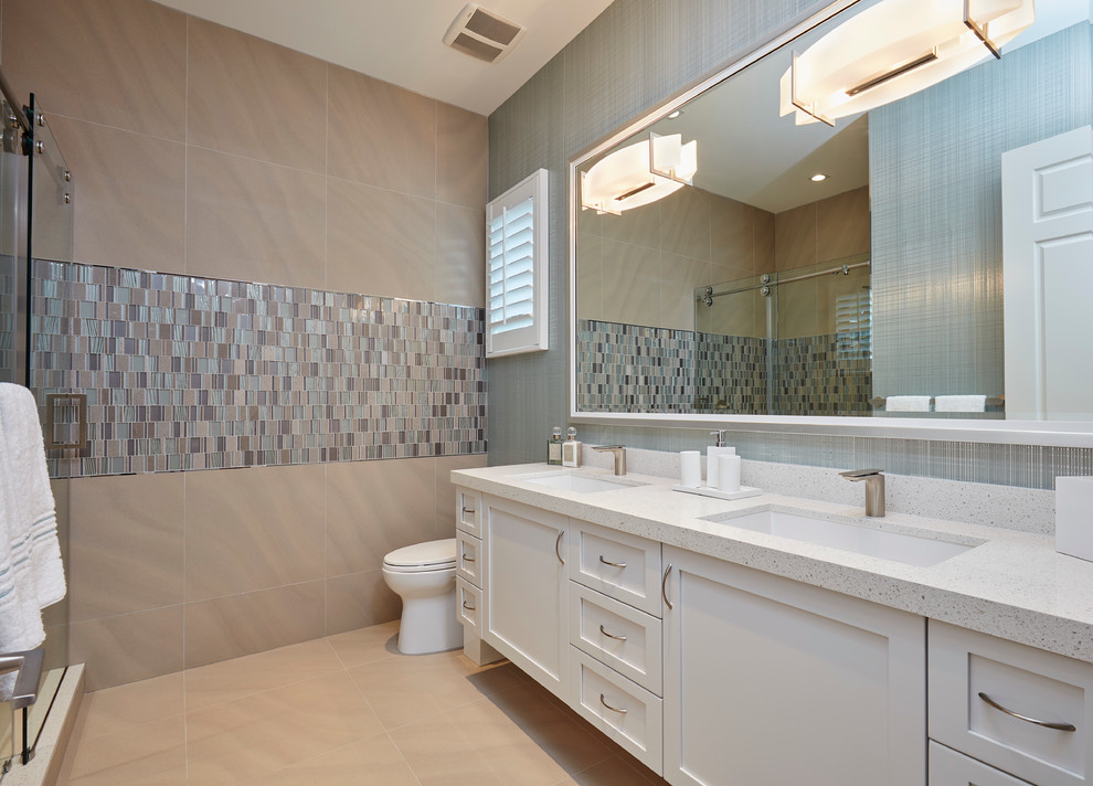 This is an example of a large contemporary master bathroom in Miami with recessed-panel cabinets, white cabinets, a drop-in tub, an open shower, beige walls, ceramic floors, an undermount sink, terrazzo benchtops, beige floor and a sliding shower screen.