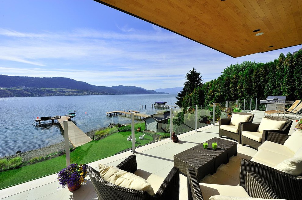 Mid-sized modern rooftop deck in Vancouver with a fire feature and a roof extension.