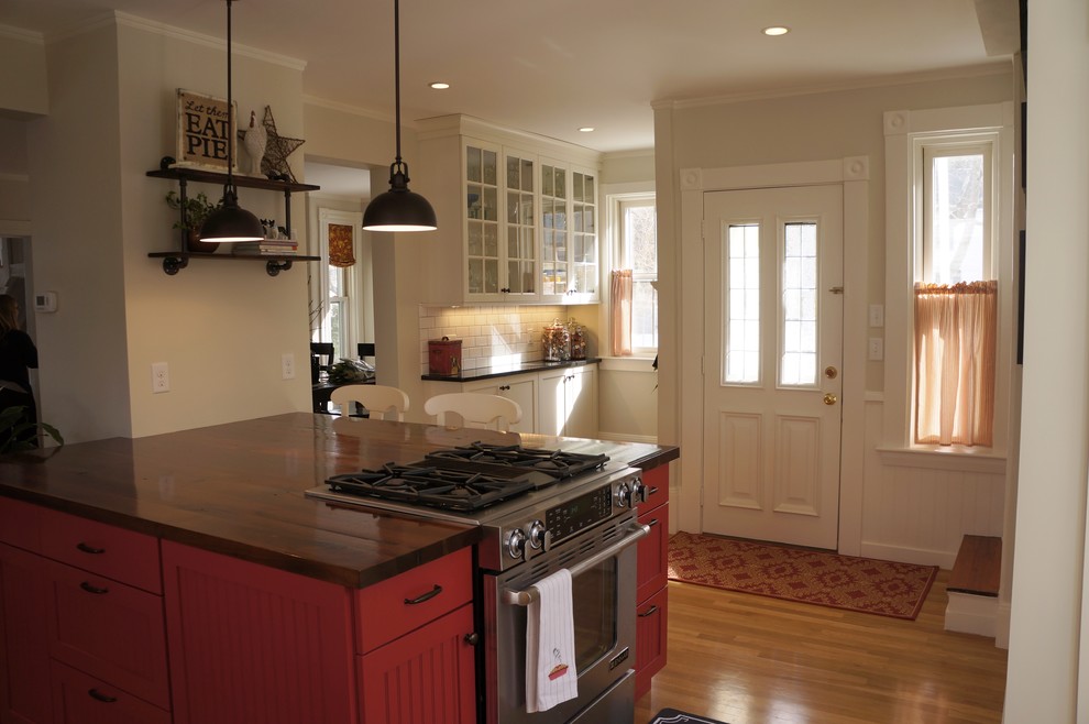 Enclosed kitchen - small rustic l-shaped light wood floor and beige floor enclosed kitchen idea in Boston with an undermount sink, recessed-panel cabinets, granite countertops, white backsplash, subway tile backsplash, stainless steel appliances, an island, white cabinets and black countertops