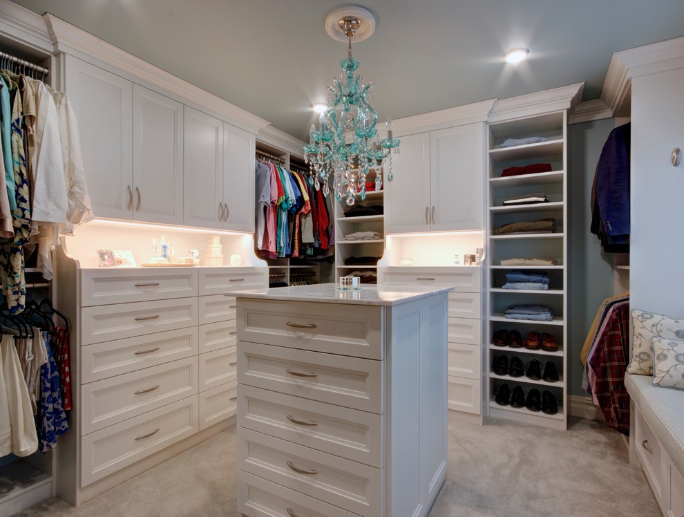 This is an example of a large traditional gender-neutral walk-in wardrobe in Other with white cabinets, carpet, beige floor and recessed-panel cabinets.