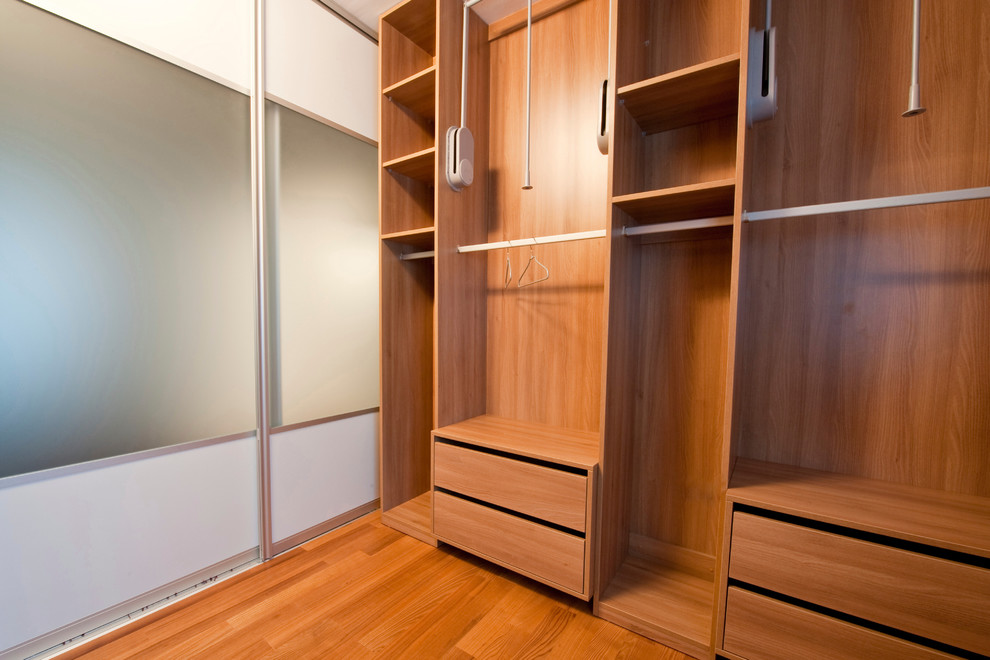 Photo of a mid-sized modern gender-neutral walk-in wardrobe in Miami with flat-panel cabinets.