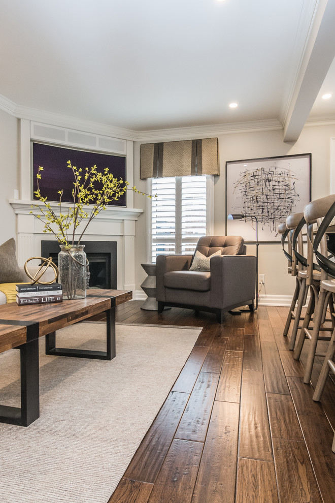 This is an example of a mid-sized transitional open concept living room in Other with grey walls, medium hardwood floors, a corner fireplace, a wood fireplace surround, a wall-mounted tv and brown floor.