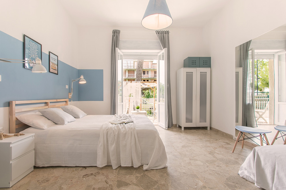 Beach style master bedroom in Florence with white walls and grey floor.