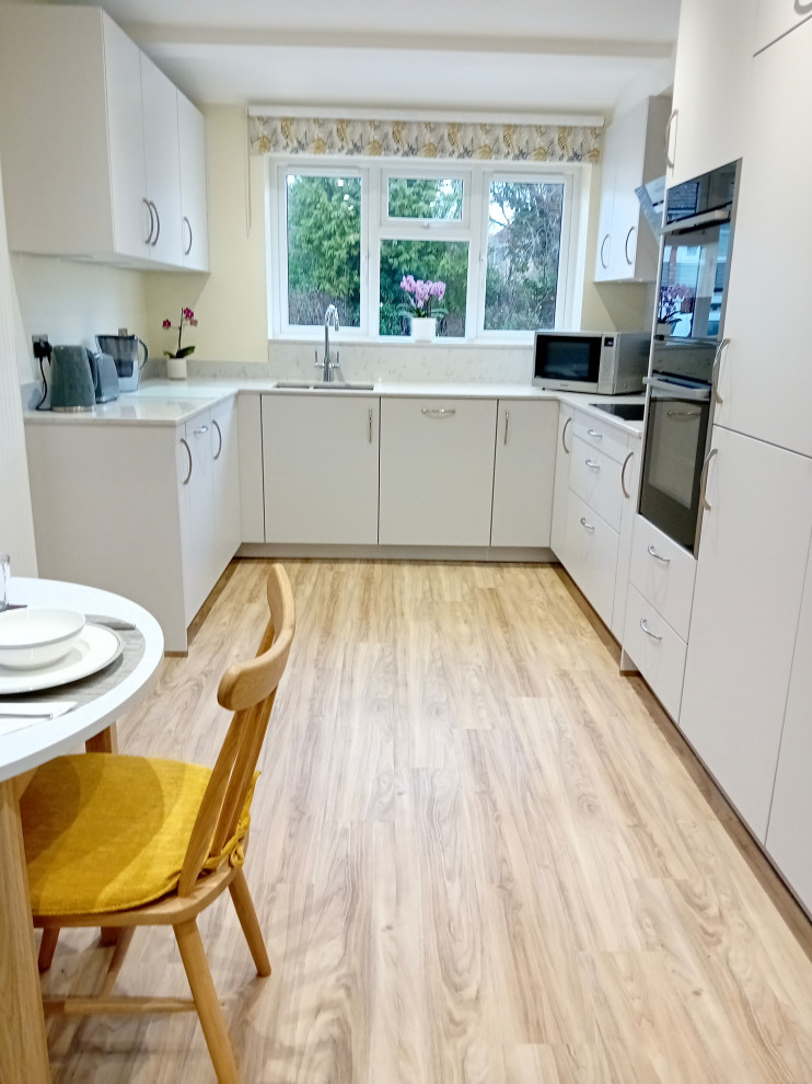 Inspiration for a medium sized modern u-shaped kitchen/diner in Berkshire with flat-panel cabinets, grey cabinets, quartz worktops and white worktops.