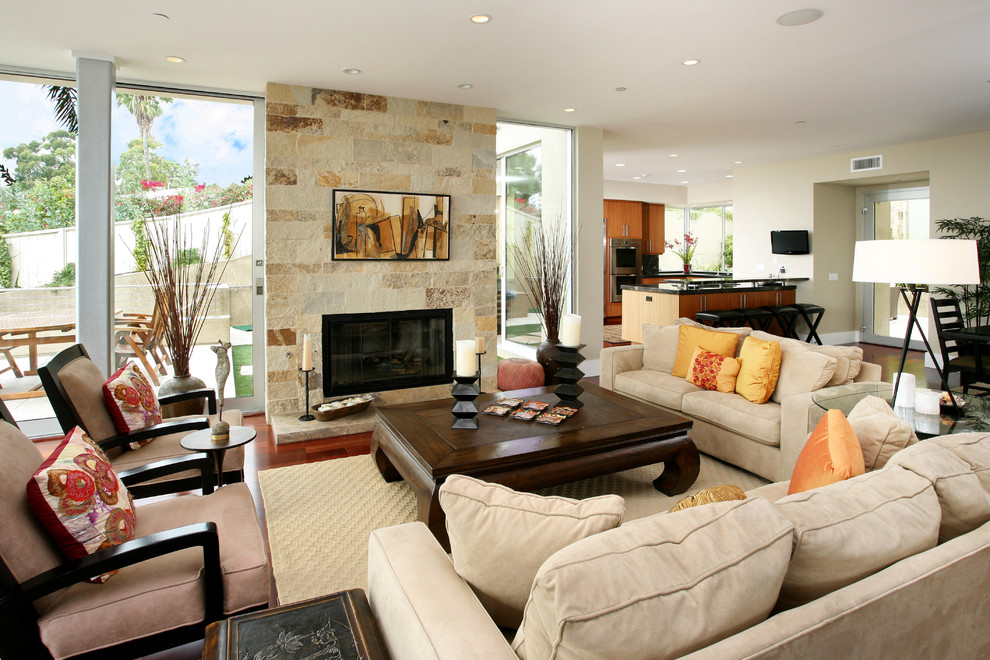 Photo of a tropical living room in Orange County with a stone fireplace surround.
