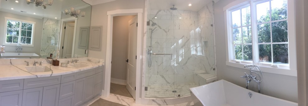 Inspiration for a mid-sized contemporary master bathroom in Other with shaker cabinets, grey cabinets, a freestanding tub, an alcove shower, gray tile, porcelain tile, grey walls, marble benchtops, grey floor, a hinged shower door, a one-piece toilet, porcelain floors and a drop-in sink.