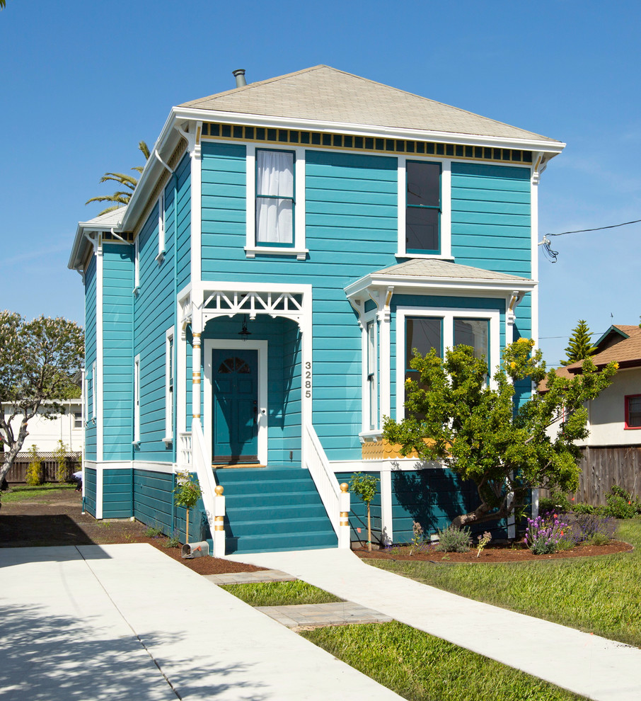 This is an example of a traditional two-storey blue house exterior in San Francisco with wood siding, a hip roof and a shingle roof.